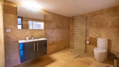 Un baño con inodoro, lavabo y espejo. en VİLLA OZ, en Kas