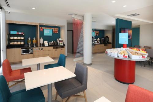 a restaurant with tables and chairs and a counter at avid hotel Guadalajara Aeropuerto Norte in Guadalajara