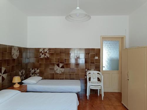 une chambre avec deux lits et une table et des chaises dans l'établissement Casa Nettuno, à Lido Conchiglia