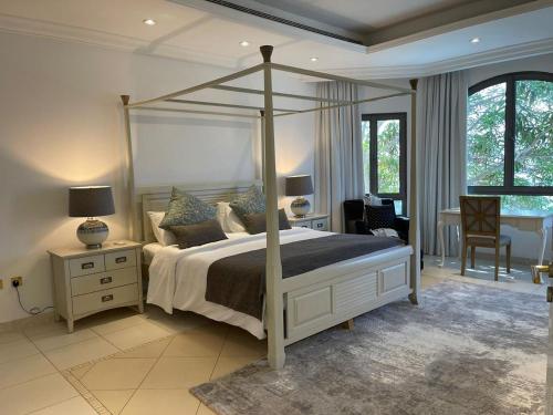 a bedroom with a canopy bed and a desk at Palm Jumeirah Beachfront private pool villa 5 BR & 1 maids room with access to beach in Dubai