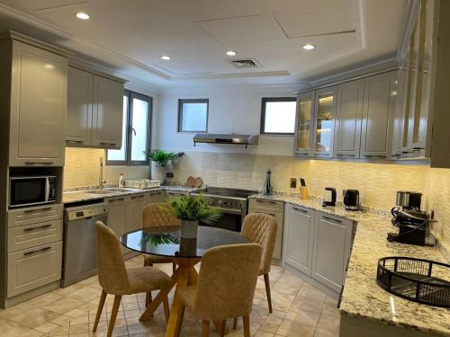 a large kitchen with a table and chairs in it at Palm Jumeirah Beachfront private pool villa 5 BR & 1 maids room with access to beach in Dubai