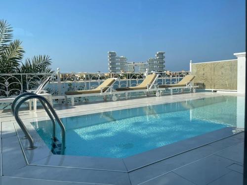 a swimming pool with lounge chairs and a swimming pool at Palm Jumeirah Beachfront private pool villa 5 BR & 1 maids room with access to beach in Dubai