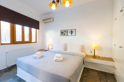 a bedroom with a white bed with two towels on it at The Bridge House in Spílion