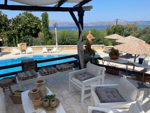 a patio with chairs and a swimming pool at Villas Vista Del Mar in Kissamos