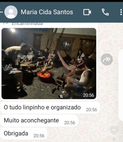 a screenshot of a video of people sitting around a fire at Sítio Estrela da Manhã Hospedagem e Lazer in Palmeiras