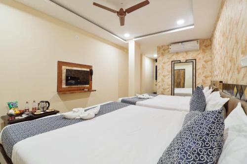 a hotel room with two beds and a tv at Hotel Galaxy Park in Shamshabad