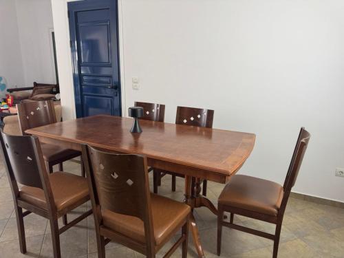 a wooden table with chairs and a vase on it at Tinos beauty village in Kalloní