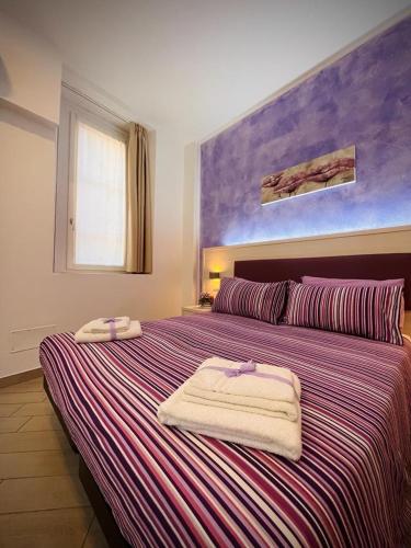 a bedroom with a large bed with towels on it at BelSorriso Varese 2 - Elegance City Residence with Private Parking -Reservation Required- in Varese