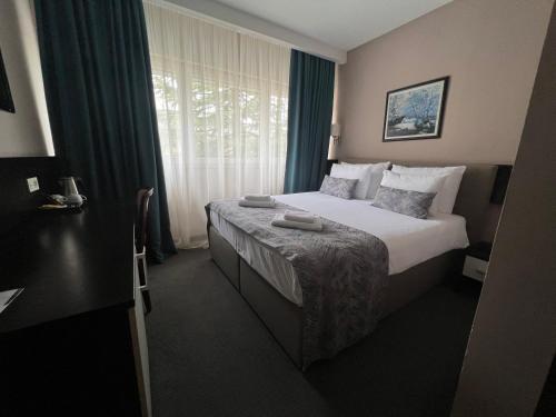 a hotel room with a bed and a window at Garden City Hotel Konjic in Konjic