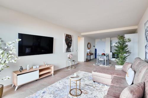 a living room with a couch and a tv on a wall at Apartamentos Golfinho Dourado in Santa Maria