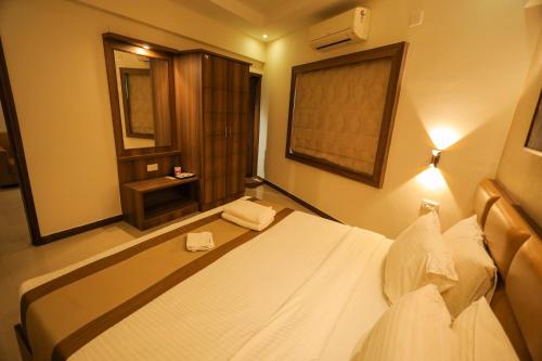 a bedroom with a white bed and a window at Metro Plaza Hotel by RAK Rooms, Mangaluru in Mangalore