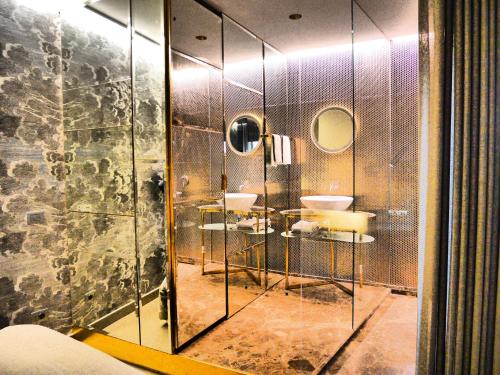 ヴェローナにあるRiverview Suiteの洗面台3つとガラスの壁が備わるバスルーム