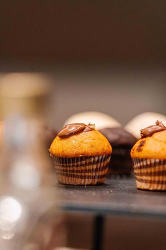 three muffins with chocolate on top on a table at Living Hotel Milano in Cornaredo