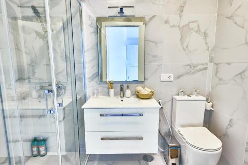 a bathroom with a shower and a toilet and a sink at Apartamentos Golfinho Dourado in Santa Maria