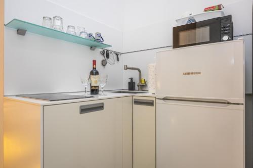 a kitchen with a white refrigerator and a microwave at Villa Erika Crikvenica in Crikvenica