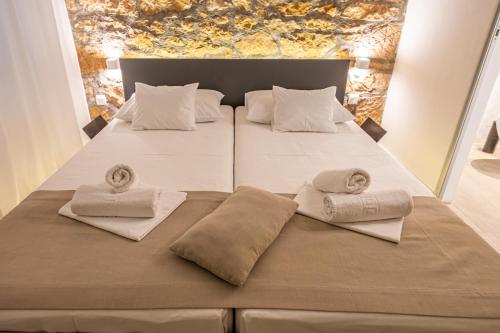 a bed with two pillows and towels on it at Villa Erika Crikvenica in Crikvenica