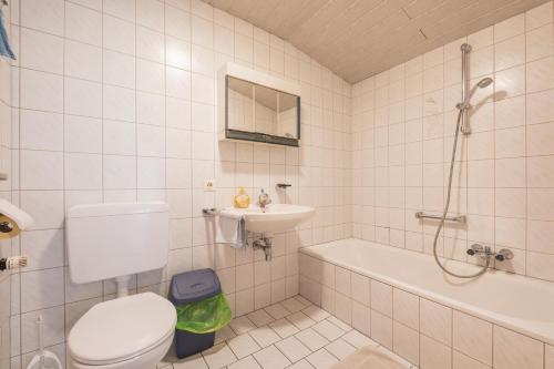 a bathroom with a toilet and a sink and a tub at Ferienwohnung Kirchbrücke in Mieders
