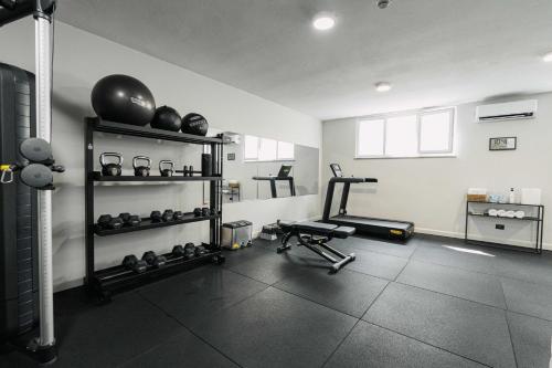 a room with a gym with weights and a treadmill at Living Hotel Milano in Cornaredo