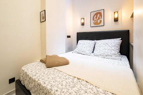 a bedroom with a large bed with white sheets at 5 Guests Flat - Marais Enfants Rouges in Paris