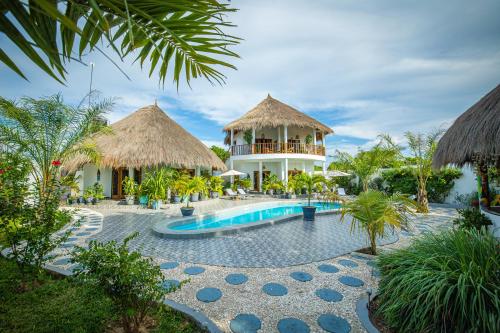 a resort with a swimming pool and a building at TinJaLa Lodge in Brufut