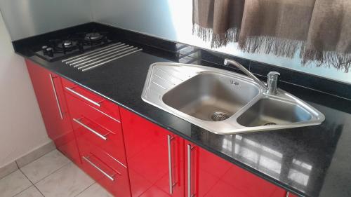 a kitchen counter with a sink and a stove at Embruns 2 in Le Moule