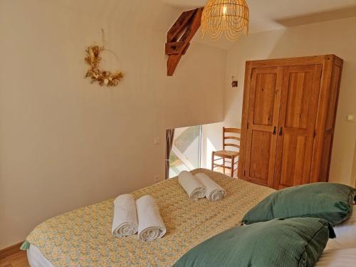 a bedroom with a bed with towels on it at Le Chaussis in Aron