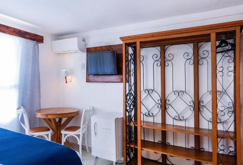 a bedroom with a bed and a cabinet at Hotel Village Enseada in Ubatuba