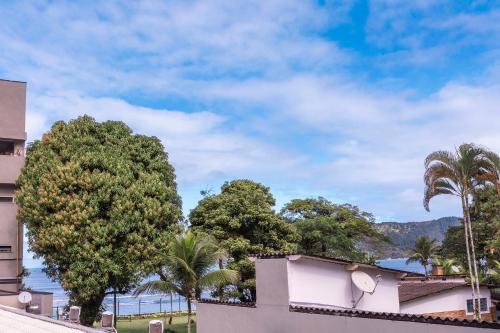 a view of the water from a building and trees at Hotel Village Enseada in Ubatuba