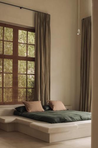 a large bed in a room with a window at Jonojé Luxury Suites in Bruges
