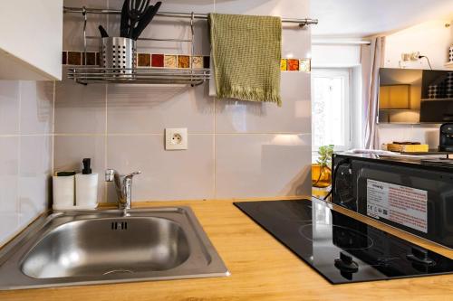a kitchen with a sink and a microwave at Studio in heart of Paris in Paris
