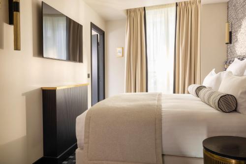 a hotel room with a bed and a window at Hôtel Filigrane & Spa in Paris