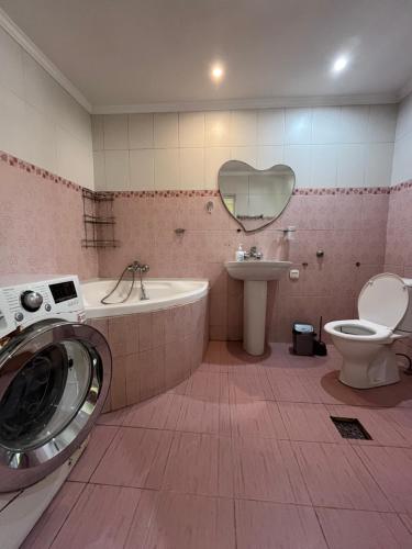 Un baño con lavadora y lavabo. en Home V, en Odessa