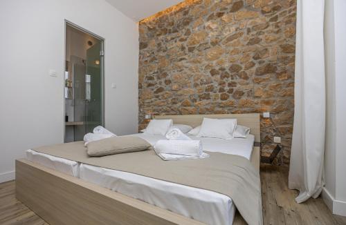 a bed in a room with a brick wall at Villa Erika Crikvenica in Crikvenica