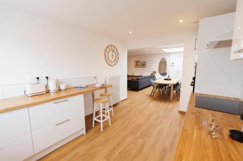 a kitchen and living room with white cabinets and a table at le 3 Tassigny in Colmar