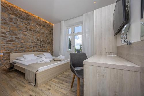 a bedroom with a bed and a chair in a room at Villa Erika Crikvenica in Crikvenica