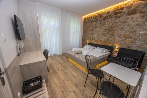 a bedroom with a bed and a stone wall at Villa Erika Crikvenica in Crikvenica