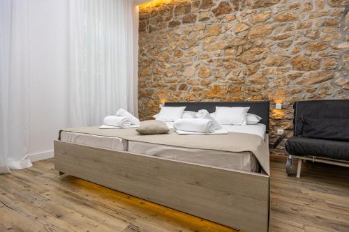 a bedroom with a large bed with a stone wall at Villa Erika Crikvenica in Crikvenica