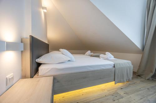 a bedroom with a bed with white sheets and pillows at Villa Erika Crikvenica in Crikvenica