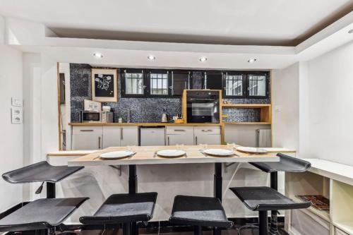 - une cuisine avec une grande table et des tabourets dans l'établissement Bluestay 3 - Appartement au Cœur de Paris, à Paris