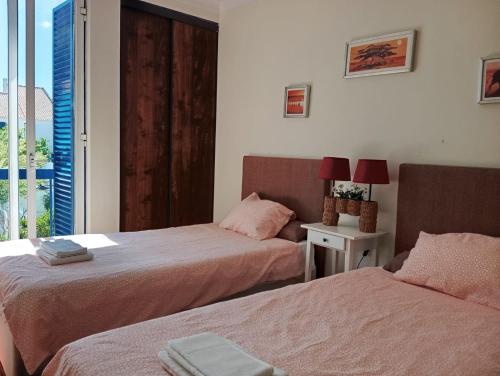 a bedroom with two beds and a window with a view at Villa Arrábida in Palmela
