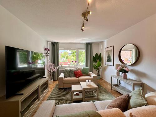a living room with a couch and a tv at Prinshöjden Hotel - Smart Digital Apartments & Villas in Katrineholm