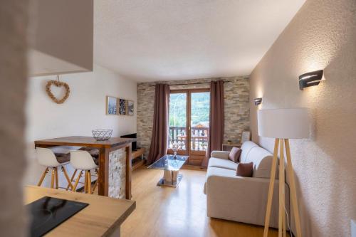 un salon avec un canapé et une table dans l'établissement La Ruinée Appartement chaleureux à proximité des pistes et commodités, à Briançon