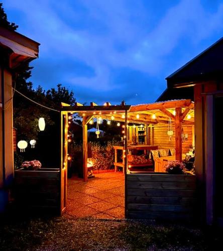 an outdoor patio with a pergola at night at Enebolig til 9 gjester nær Oslo lufthavn in Eidsvoll