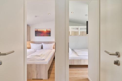 un dormitorio con una cama y un espejo en Ostseecamp Ferienhaus "Sauerländer", en Scharbeutz