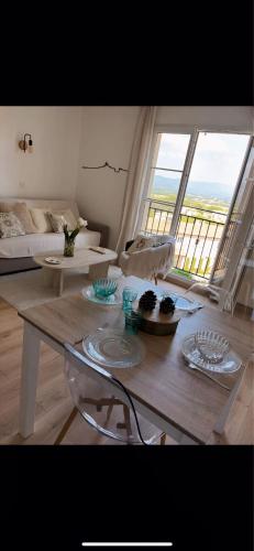 un salon avec une table et une grande fenêtre dans l'établissement Magnifique appartement lumineux avec piscine, à Mallemort