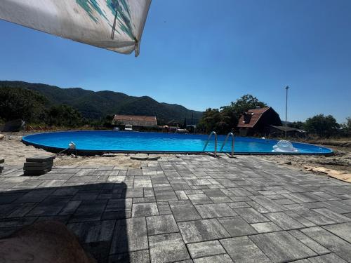 a large blue swimming pool with mountains in the background at Casa Amnisty in Liubcova