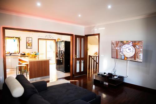 a living room with a couch and a kitchen at Sta Luzia Villa Douro in Amarante