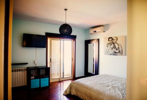 a bedroom with a bed and a sliding glass door at Sta Luzia Villa Douro in Amarante