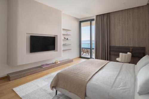 a bedroom with a large bed and a television at Kuk Oaza Luxury Villas in Makarska
