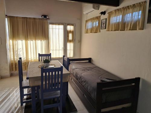 a bedroom with a bed and a table and chairs at Lo de lili in Ramallo